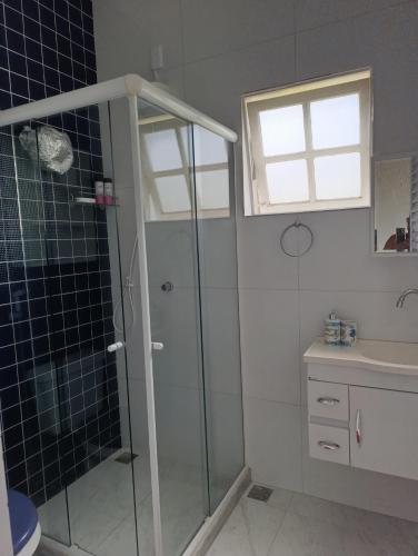 a bathroom with a shower and a sink at Cantinho da vovó Sol in Cabo Frio