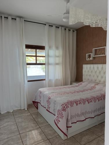 a bedroom with a bed and a window at Cantinho da vovó Sol in Cabo Frio