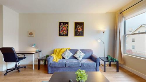 a living room with a blue couch and a table at Stylish Home with Free Parking in Stamford