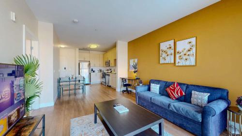 a living room with a blue couch and a kitchen at Great Charming stay in Stamford
