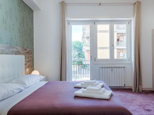 a bedroom with a bed with towels on it at Guesthouse Park Pines in Rome