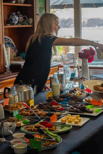 a woman standing in front of a table full of food at Arapawa Homestead in Picton