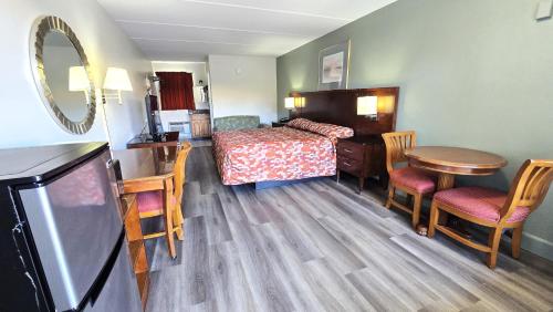 a hotel room with a bed and a table and chairs at Gulf Way Inn Clearwater in Clearwater