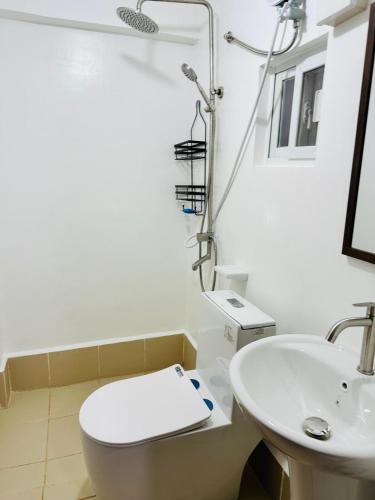 a bathroom with a toilet and a sink at Casa Del Sol! 2BR Puerto Princesa in Puerto Princesa City