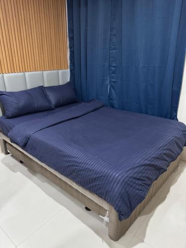 a bed with blue sheets and blue pillows on it at Jo Condotels at Persimmon Tower3 in Cebu City