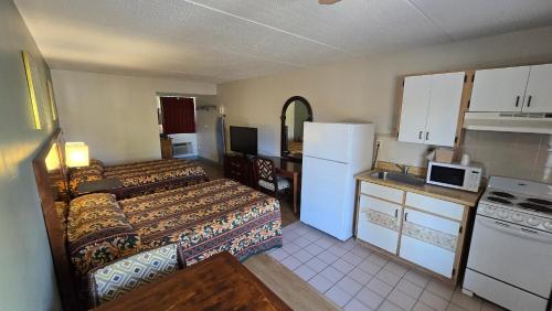 a small hotel room with two beds and a kitchen at Gulf Way Inn Clearwater in Clearwater