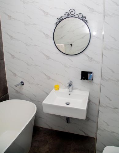 a bathroom with a sink and a mirror on the wall at Wangu Urban in Mpemba