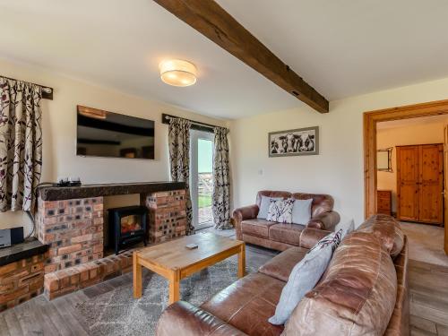 a living room with a couch and a fireplace at Milking Parlour - Uk48911 in Allonby