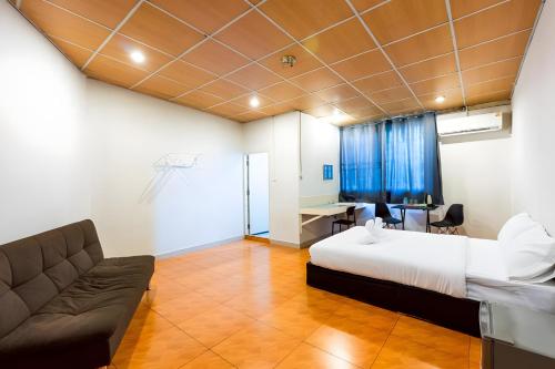 a bedroom with a bed and a couch and a desk at XX At Gate Suvarnabhumi Airport - อ่อนนุช in Ban Khlong Prawet