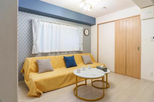 a living room with a yellow couch and a table at 新装オープン 5名 立地良好 閑静 新宿4分 渋谷17分 池袋22分 カップル 家族 in Tokyo