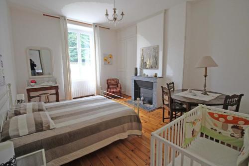 a bedroom with a bed and a desk and a fireplace at Brenac in Eymoutiers