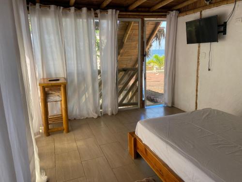a bedroom with a bed and a sliding glass door at Villa en Salango con piscina in Salango