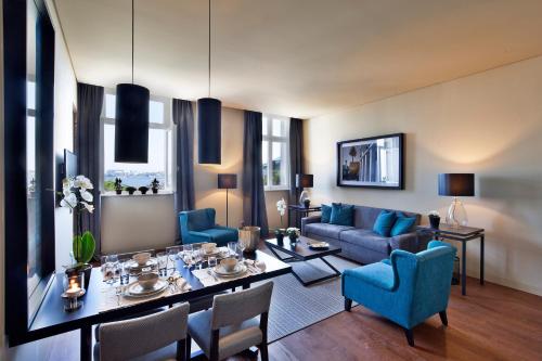 a living room with a table and blue chairs at Lisbon Five Stars Apartments 8 Building in Lisbon