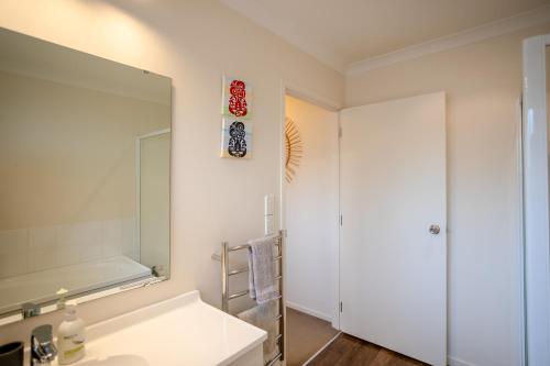 a bathroom with a sink and a mirror at Great for Couples - Families - Groups in Mangawhai