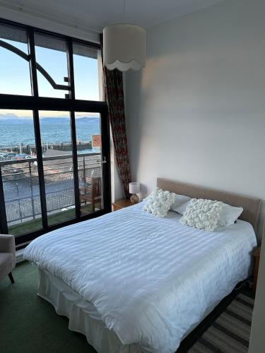 a bedroom with a bed with a view of the ocean at Seaside Penthouse 2 in Largs