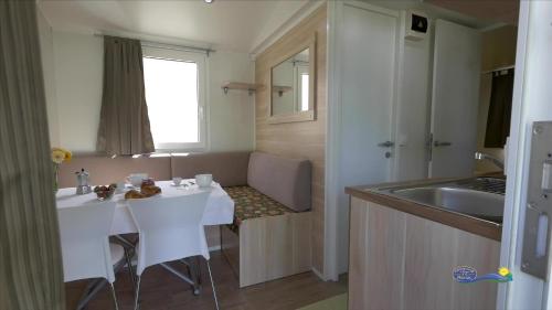 a kitchen with a white table and a sink at Camping Parisi in Baveno