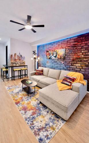 a living room with a couch and a brick wall at Hoboken Hideaway - Walk to Transit - 15 Mins to NYC in Hoboken