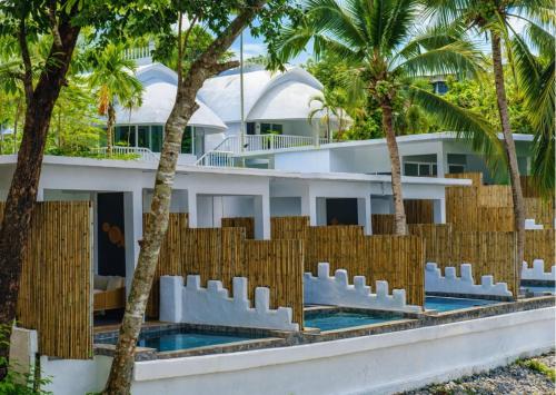 a building with palm trees in front of it at Arawan Beach Resort Krabi in Ao Nam Mao
