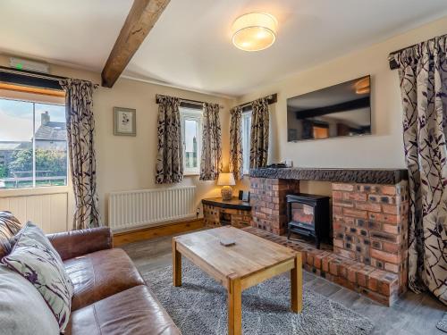 a living room with a couch and a fireplace at Milking Parlour - Uk48911 in Allonby