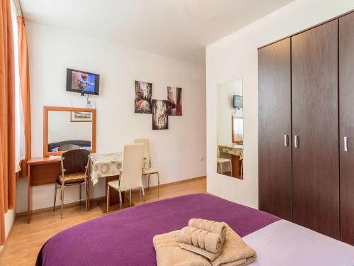 een slaapkamer met een paars bed en een tafel bij Sweet Dreams Apartments in Zadar