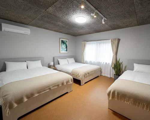 a bedroom with two beds and a window at Sunshine in Tokyo