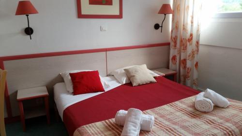 a hotel room with two beds with red and white sheets at VVF Jura Lac de Vouglans in Maisod