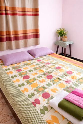 a bed with a colorful blanket on top of it at Peaceful Family Bungalow Near Mahalakshmi Temple in Kolhapur