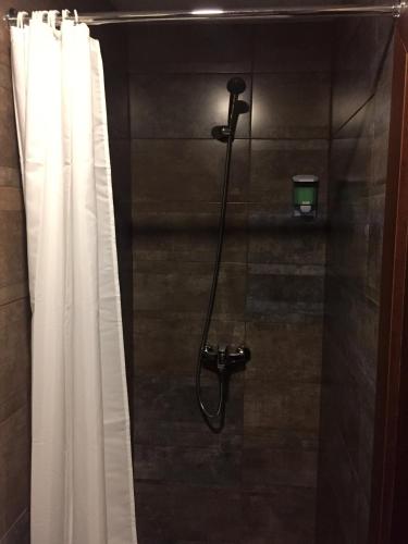a shower in a bathroom with a shower curtain at Sinclair Guest House in Abuja