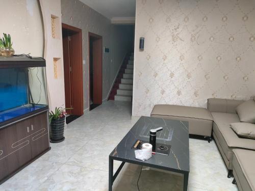 a living room with a couch and a tv at 春栖客栈 in Chuanxingpu