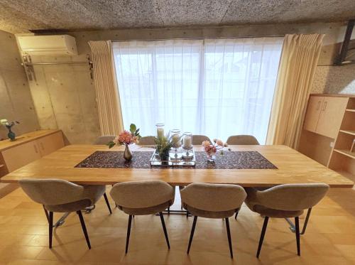 a dining room table with chairs and a large window at Sunshine in Tokyo