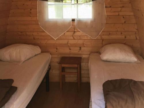 two beds in a room with a table and a window at Chalet 8 Pers - Terrasse - Equipement bébé - API-1-52-1519 in Beaudreix
