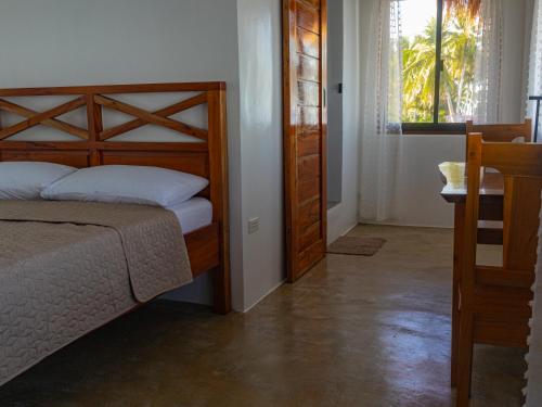 a bedroom with a bed and a table and a window at HilNer's Beach Resort in Alegria