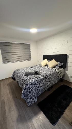 a bedroom with a bed with a black and white blanket at Condo luminity exclusivo 2D-2B incluye piscina parking y wifi gratis check in y seguridad 24 hrs in Los Ángeles