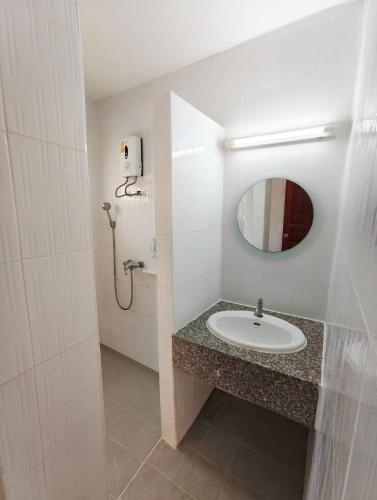 a white bathroom with a sink and a mirror at โรงแรมสบายโฮเทล โคราช in Nakhon Ratchasima