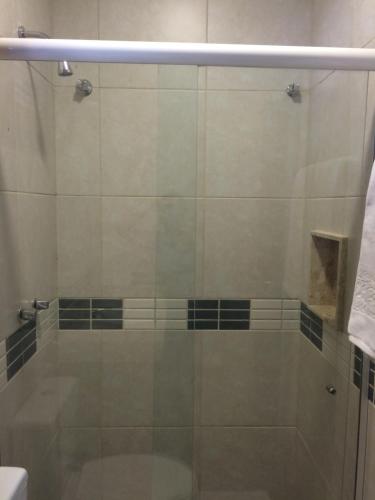 a shower with a glass door in a bathroom at Pousada Manjericão in Guaramiranga