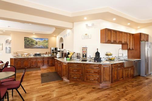 een grote keuken met houten kasten en een tafel bij Glenwood Springs Inn in Glenwood Springs