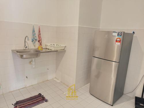 a kitchen with a stainless steel refrigerator and a sink at BayView Suites Port Dickson By MAISON in Port Dickson