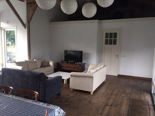 a living room with two couches and a tv at Gastenverblijf Eindhoven in Eindhoven