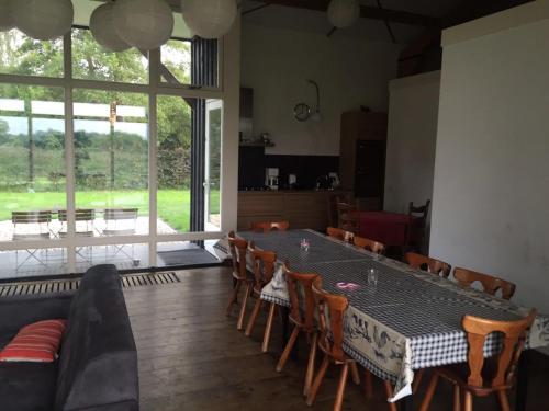 a dining room with a table and chairs and a large window at Gastenverblijf Eindhoven, 6 persoons in Eindhoven