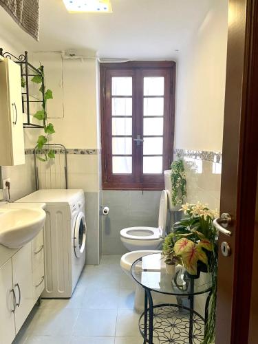 a bathroom with a sink and a toilet and a table at Porto Di Colombo - Affittacamere vicino spiaggia e città in Genoa