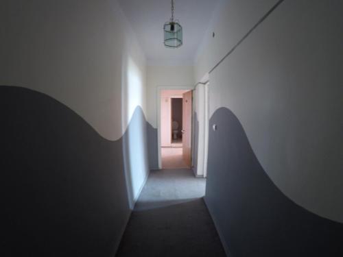 a hallway with a white wall and a door at Sevan Writers House in Sevan