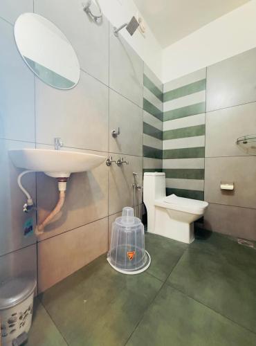 a bathroom with a sink and a toilet and a mirror at Nakshatra in Kovalam