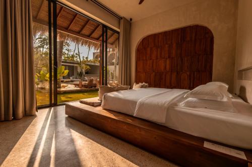 a bedroom with a large bed and a large window at Neem - Boutique Hotel Madiha - ADULTS ONLY in Kamburugamuwa