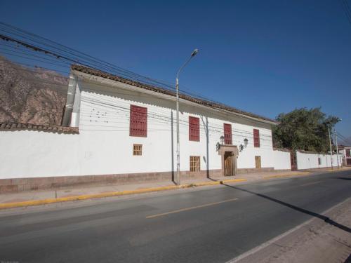 a white building on the side of a street at Hotel La Casona De Yucay Valle Sagrado in Urubamba