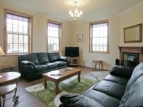 a living room with a couch and a table at Rascal Wood in Holme upon Spalding Moor