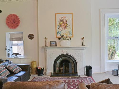a living room with a fireplace and a couch at Holly Lodge in Gilcrux