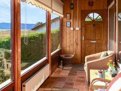 a room with a door and a view of the ocean at Achnacarry Cottage in Evelix