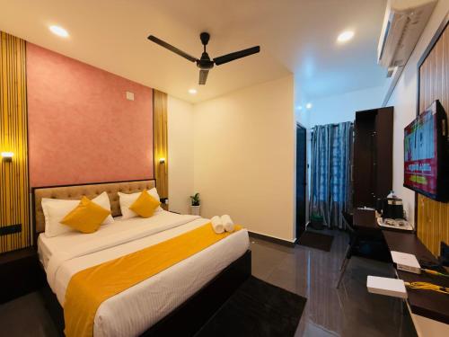 a hotel room with a bed and a flat screen tv at Nakshatra in Kovalam