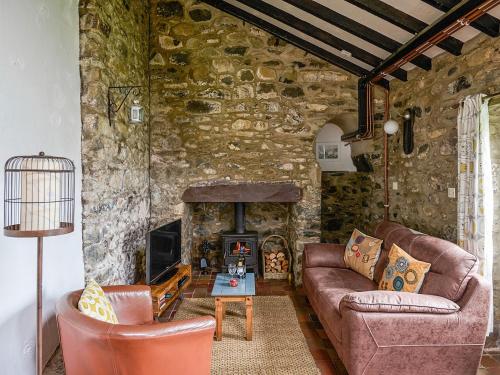 a living room with two couches and a fireplace at Bakery - Ukc4675 in Clynnog-fawr