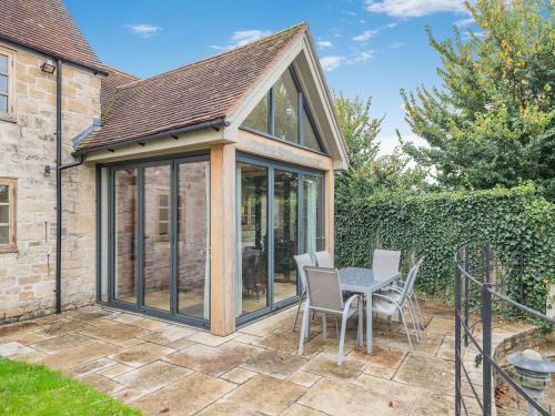 an apex conservatory with a table and chairs on a patio at New Inn Farmhouse in Marnhull
